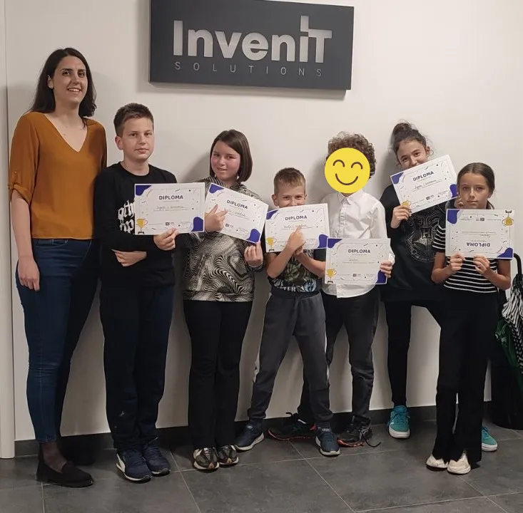 Predavač sa grupom djece nakon takmičenja u programiranju u CodeLandu